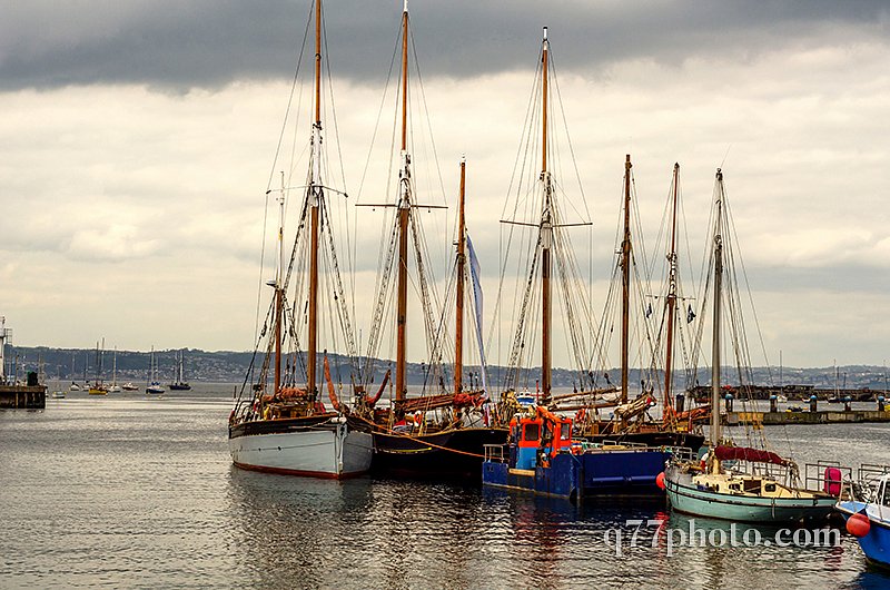 Boats anchored in a harbor, in the background stone promenade, s