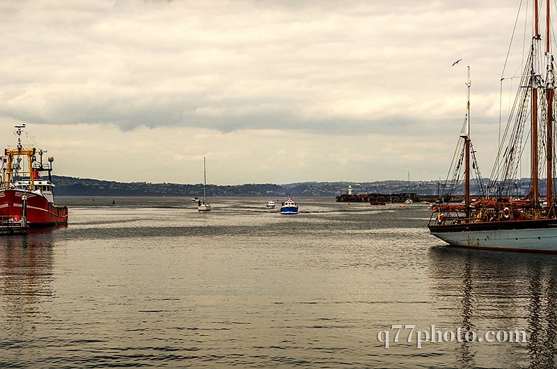 Boats anchored in a harbor, in the background stone promenade, s