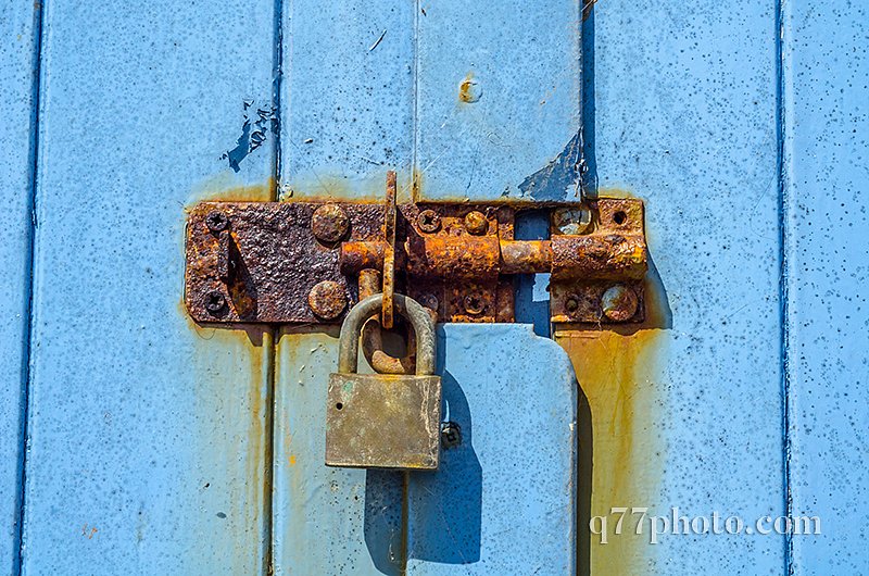 Old rusty padlock on wooden doors, old blue destroyed door, rust
