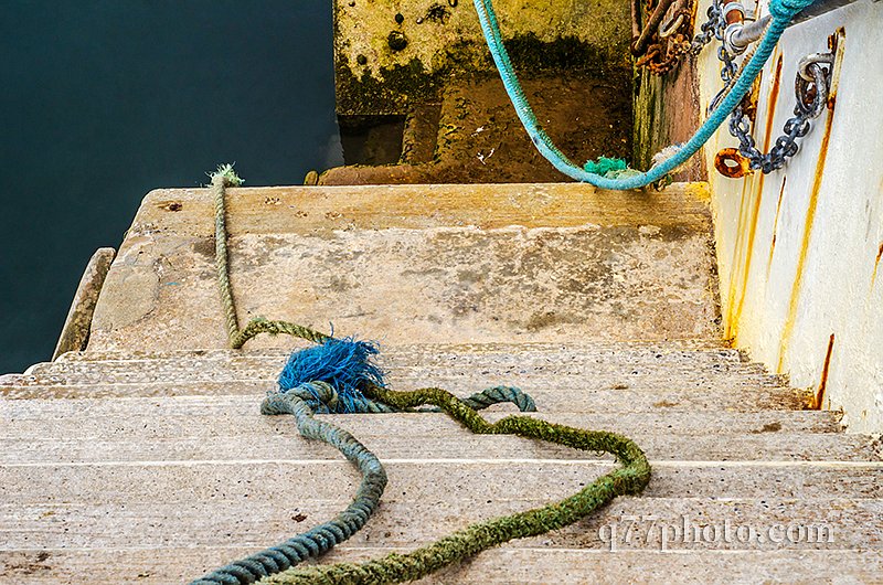 Descent down to the ocean in a fishing port, old cords and ropes